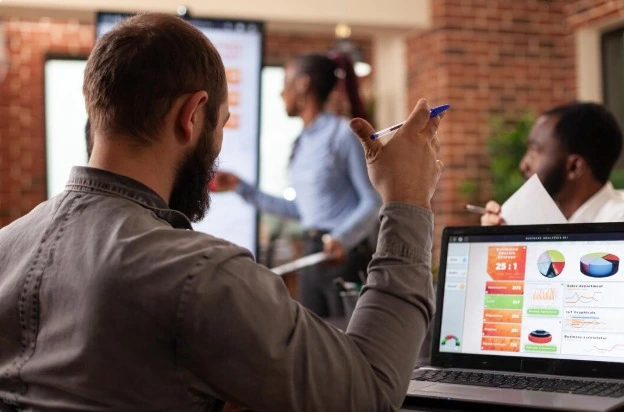 imagem mostra homem analisando dados no computador. Na imagem ele está de costas e a tela do pc estão dashboards. A imagem é utilizada para ilustrar o artigo, agência de Google ADS em São Paulo.