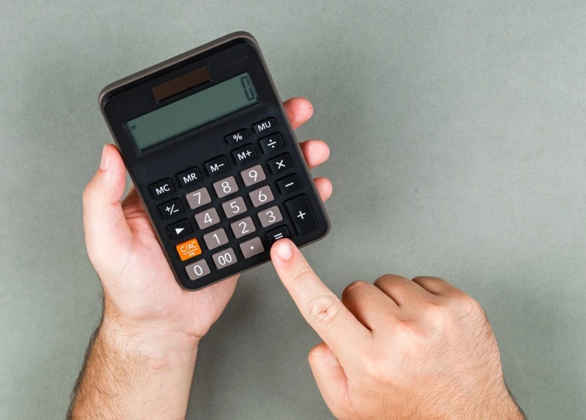 homem segurando a calculadora e digitando.
