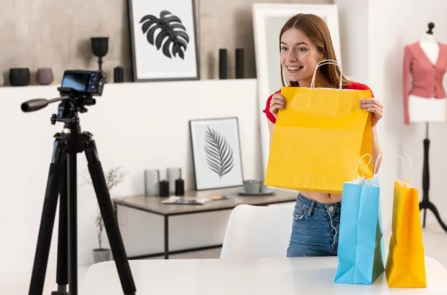 Mulher mostrando produtos em frente a celular.